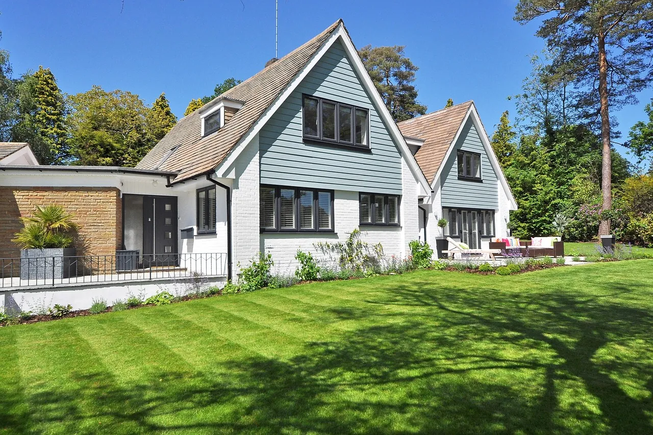 A freshly striped green lawn in front of a white two-story house